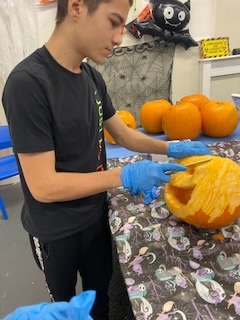 Male Student Carving Pumpkin