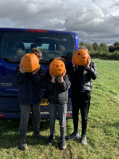 Students Holding Pumpkins To Their Face
