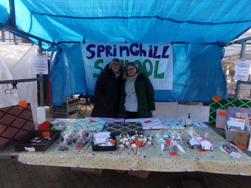 Female Staff Members Standing By Stall