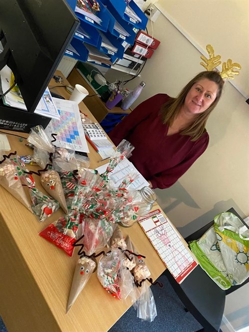 Staff Member With Xmas Hot Chocolate Packets On Desk