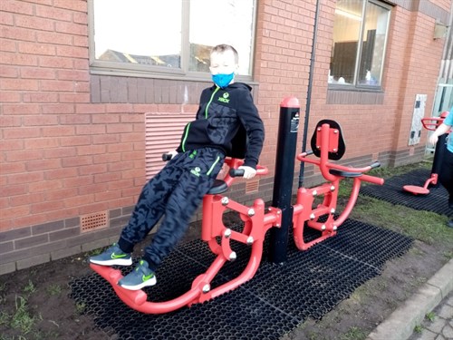 Male Student Smiling Whilst Using Gym Equipment