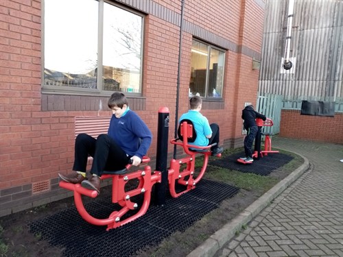 Three Male Students Using Gym Equipment