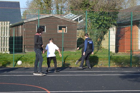 Police Officer Playing Football With Students