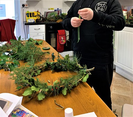 Student Adding Ribbon To Their Biodegradable Wreaths For Christmas